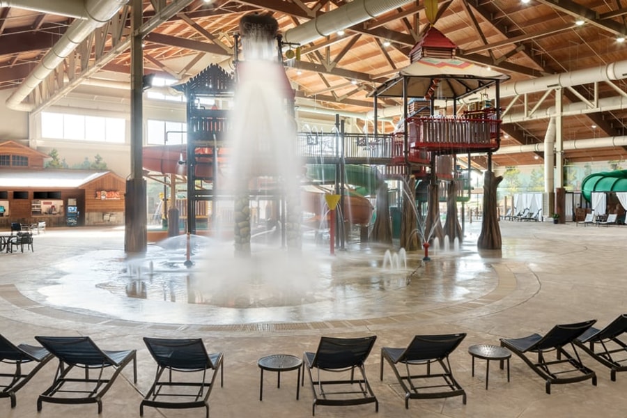 A wide shot of the  water treehouse as water splashes down from a bucket above the jungle gym
